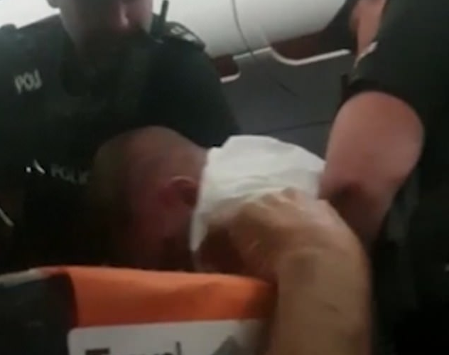 A man was forcibly removed from a plane after locking himself in the toilets just before landing and refusing to come out.Kieran Crowley, 44, was arrested on arrival when the easyJet flight from Faro, Portugal landed at Gatwick airport.By the time cabin crew managed to get him back in his seat, the landing had to be aborted as they had failed to secure the cabin, adding 40 minutes to the journey by the time the aircraft had landed, taxied and waited on the runway for police to arrive.Crowley was quiet for most of the flight, according to fellow passengers, only becoming disruptive when the fasten seatbelt signs came on. The Londoner demanded to go to the toilet and pushed past crew to lock himself in the cubicle for 10 minutes.Flight attendants knocked on the door every few minutes or so and asked him to take his seat, before finally unlocking the door, at which point onlookers report he became angry.Fellow passenger Tom Porter, 24, told the Daily Mail that Crowley was this “angry, wild animal, and didn’t want taming” and said he started swearing at anyone who looked at him, telling them to die. “The whole episode was shocking, and not what you want to see,” added Porter.When Crowley heard the pilot announce that police were on their way, he reportedly tried to lock himself in the toilet again, but was blocked by a member of cabin crew.Video of the incident shows police officers having to restrain Crowley and drag him off the aircraft after he refused to comply. Applause and cheers from passengers can be heard as he was removed.Crowley was charged with using abusive and threatening language and behaviour that was “racially aggravated”, according to Sussex police.He was also charged with “two counts of assault on an emergency worker (two police officers) and assault on an emergency worker (a police officer) in the exercise of their duty.”EasyJet confirmed the incident took place onboard flight EZY8926 and said in a statement: “While such incidents are rare we take them very seriously, do not tolerate abusive or threatening behaviour onboard and always push for prosecution.“EasyJet’s cabin crew are trained to assess and evaluate all situations and to act quickly and appropriately to ensure that the safety of the flight and other passengers is not compromised at any time. “Safety is always easyJet’s highest priority.” Crowley has been released on bail and is due to appear before Crawley Magistrates’ Court on 19 June.