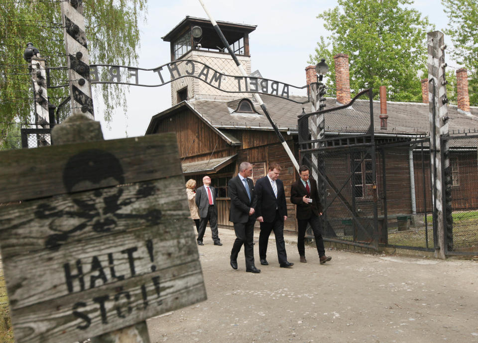 Canada’s Foreign Minister John Baird, second right, walks through the ill-omened “Arbeit Macht Frei” (Work Sets You Free) gate of the World War II Nazi German death camp of Auschwitz in Oswiecim, Poland, Thursday, April 24, 2014. Between 1940-45, the German Nazis killed over 1.1 million people, mostly Jews, in Auschwitz and in neighboring Birkenau. Baird also visited an exhibition that documents the atrocities and preserves the memory of the victims. He placed white and red roses at the Executions Wall, where inmates, chiefly Polish resistance fighters, were shot. (AP Photo/Czarek Sokolowski)