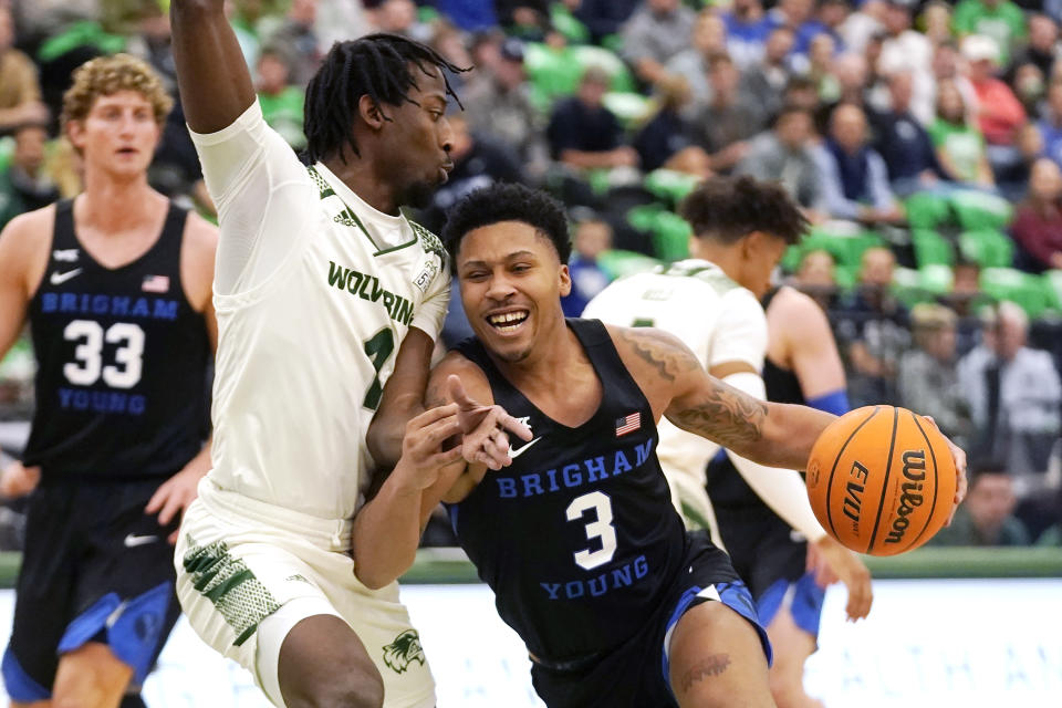 BYU guard Te'Jon Lucas (3) drives around Utah Valley guard Le'Tre Darthard (1) in the first half during an NCAA college basketball game Wednesday, Dec. 1, 2021, in Orem, Utah. (AP Photo/Rick Bowmer)