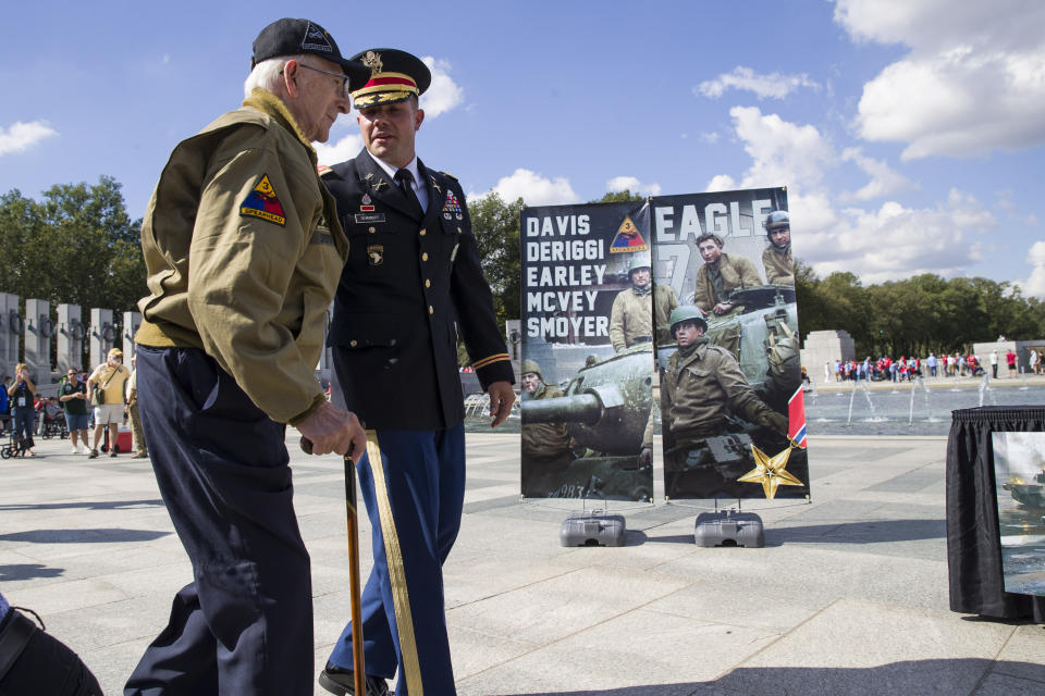 World War II veteran Clarence Smoyer, 96, left, walks to receives the Bronze Star from U.S. Army Maj. Peter Semanoff, right, at the World War II Memorial, Wednesday, Sept. 18, 2019, in Washington. Smoyer fought with the U.S. Army's 3rd Armored Division, nicknamed the Spearhead Division. In 1945, he defeated a German Panther tank near the cathedral in Cologne, Germany — a dramatic duel filmed by an Army cameraman that was seen all over the world. (AP Photo/Alex Brandon)