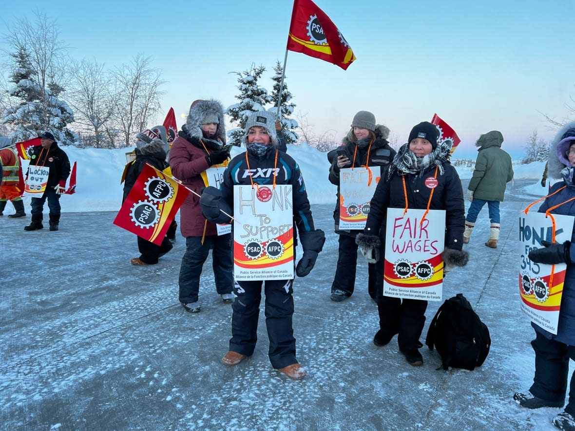 Yellowknife municipal workers outside of city hall on Wednesday morning. Temperatures hovered around -30 C.  (Hilary Bird/CBC - image credit)