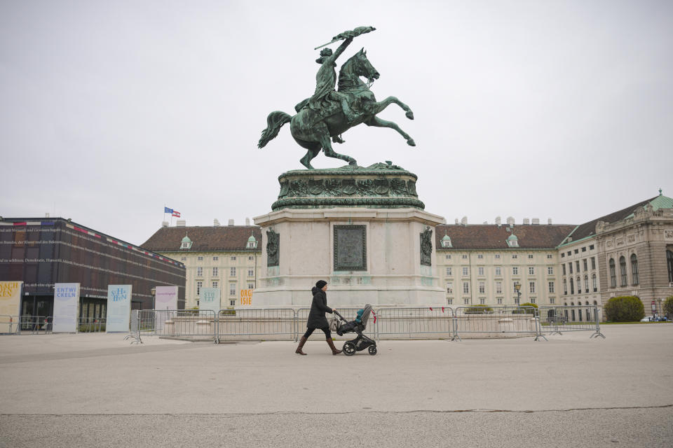 A woman pushes a baby stroller in Vienna, Austria, Monday, Nov. 22, 2021. Austria went into a nationwide lockdown early Monday to combat soaring coronavirus infections, a step being closely watched by other European governments struggling with national outbreaks that are straining health care systems.(AP Photo/Vadim Ghirda)