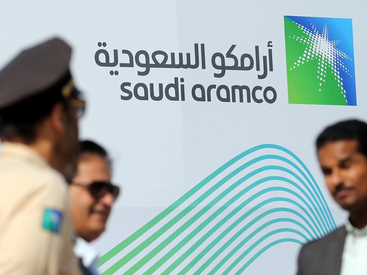 Logo of Aramco behind security personnel.