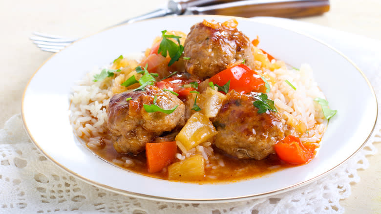 Meatballs with pineapple over rice on plate