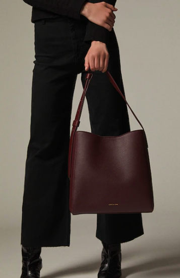 Model carries top handle Everywhere Hobo Tote in burgundy