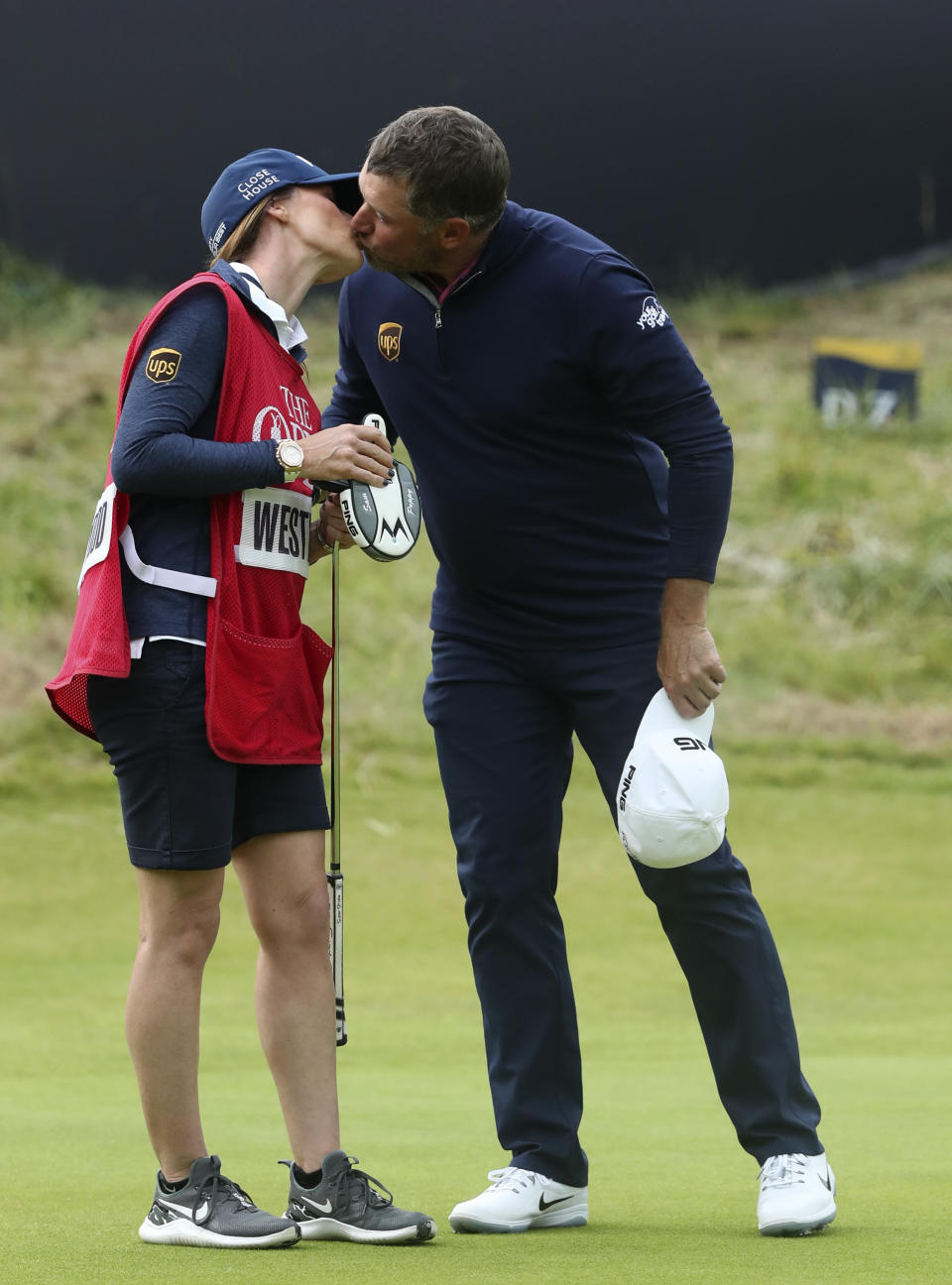 England's Lee Westwood kisses his caddie and girlfriend Helen Storey on the 18th green after completing his third round of the British Open Golf Championships at Royal Portrush in Northern Ireland, Saturday, July 20, 2019.(AP Photo/Jon Super)