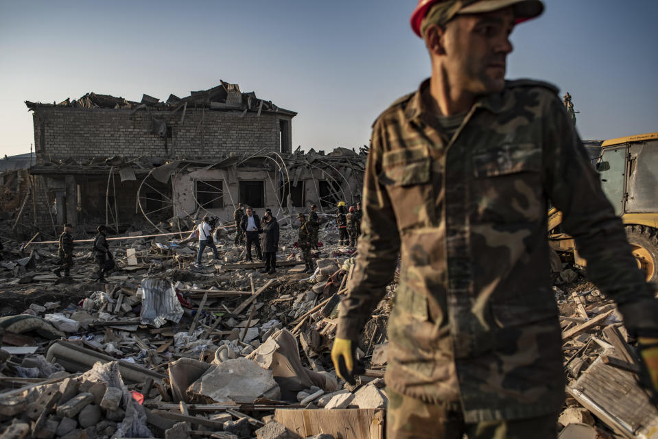 Azerbaijani soldiers and firefighters look for survivors from destroyed houses in a residential area in Ganja, Azerbaijan's second largest city, near the border with Armenia, after rocket fire overnight by Armenian forces for second time in a week, early Saturday, Oct. 17, 2020. Azerbaijan has accused Armenia of striking its second-largest city with a ballistic missile that killed at least 13 civilians and wounded 50 others in a new escalation of their conflict over Nagorno-Karabakh. (Can Erok/DHA via AP)