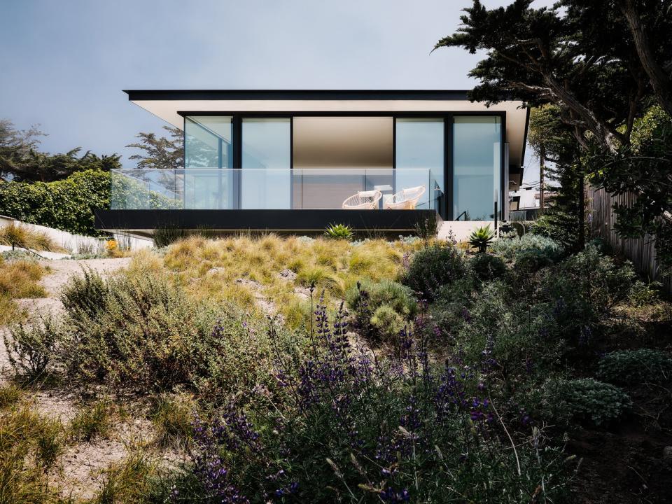 The home is built into its grassy-dune landscape (icluding a day-lit lower level) yet still appears to float over its terrain.