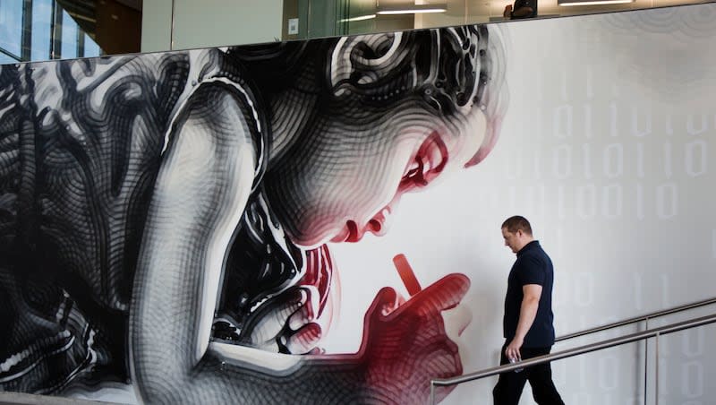 An Adobe employee walks into the cafe next to a spray-painted piece at the Adobe office in Lehi on Thursday, July 13, 2017.