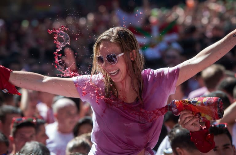 A woman is doused with wine as she celebrates the 'Chupinazo' in Pamplona, northern Spain, on July 6, 2016
