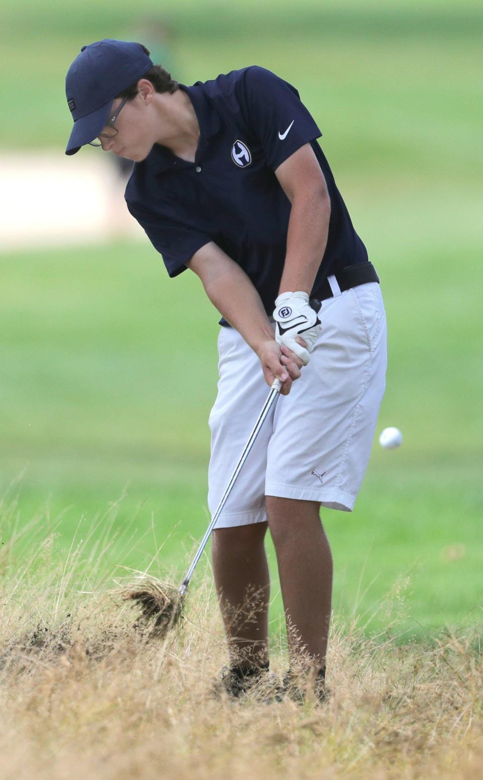 Hoban's Jake Ryan hits out of the rough on No. 8 during the Hoban Invitational.