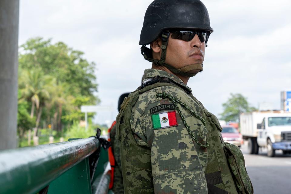 TAPACHULA, México –Un efectivo de la Guardia Nacional mexicana observa mientras un oficial de inmigración de ese país aborda un autobús que viajaba en dirección norte por la Autopista de la Costa Pacífica cerca de Tapachula. En junio, el presidente mexicano Andrés Manuel López Obrador, bajo presión de Washington, envió la Guardia Nacional a ayudar a las autoridades migratorias en los esfuerzos por bloquear el paso de migrantes centroamericanos hacia Estados Unidos.