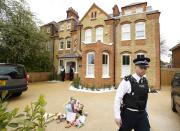 A police officer walks outside a house where the bodies of three children were found, in New Malden, southwest London April 23, 2014. A 43-year-old woman has been arrested on suspicion on murder after the bodies of three children were found at a house in southwest London, police said on Wednesday. Police said a four-year-old girl and two boys, both aged three, were found dead at a residential address in New Malden on Tuesday evening. REUTERS/Olivia Harris (BRITAIN - Tags: CRIME LAW SOCIETY)