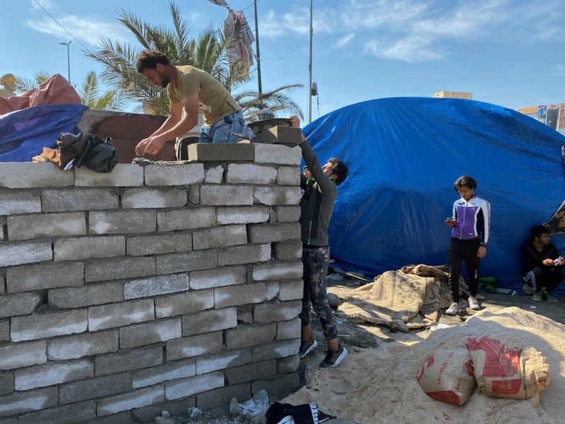 Iraqi demonstrators build camps with bricks to replace tents that were set on fire by unidentified gunmen during ongoing anti-government protests in Nassiriya