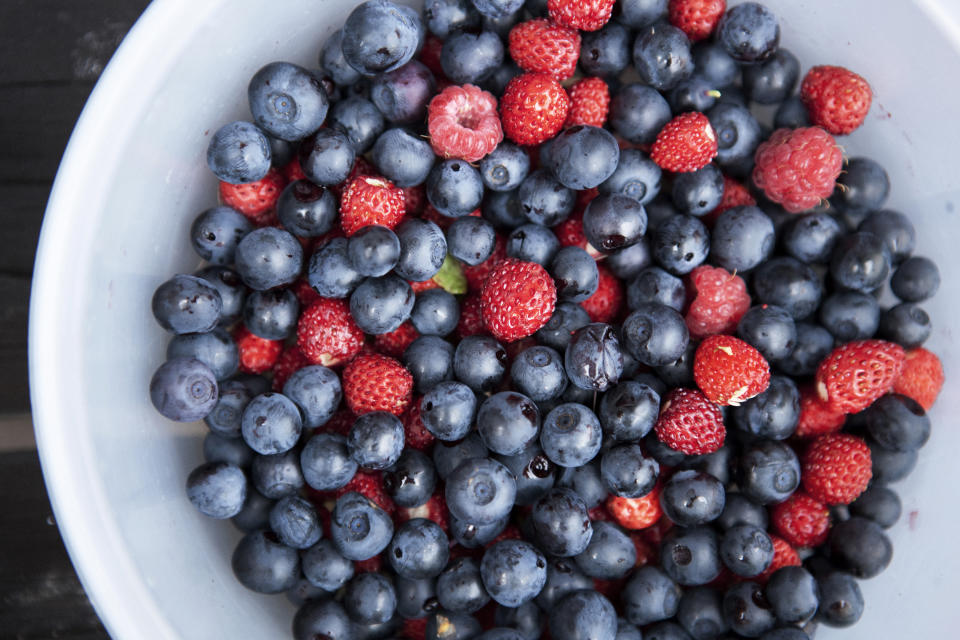 Strawberries, blueberries and raspberries in a white bowl