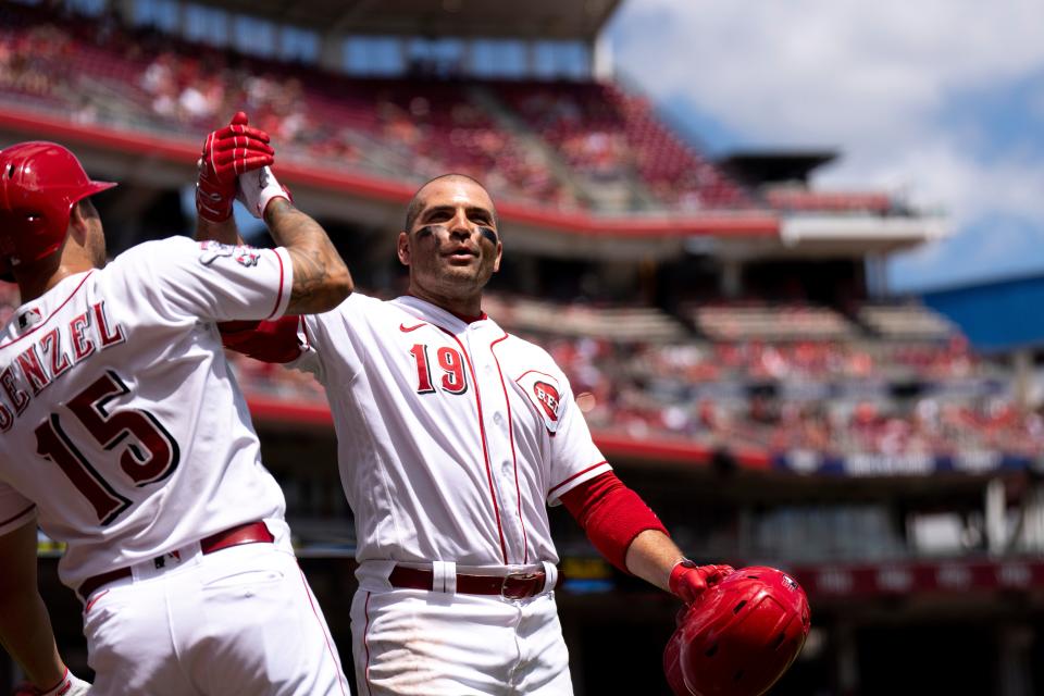 Cincinnati Reds first baseman Joey Votto (19) grabs Cincinnati Reds third baseman Nick Senzel (15) after hitting a solo home run in the second inning of the MLB baseball game between Cincinnati Reds and Washington Nationals at Great American Ball Park in Cincinnati on Sunday, Aug. 6, 2023. 