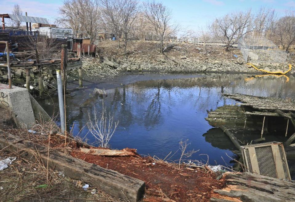 This Saturday, April 5, 2014 photo shows Steinway Creek shortly after police recovered a 2009 Honda Accord from its waters in New York. The driver of the car drove off a dead-end street in a desolate industrial area, flipped over a wooden curb into the East River inlet killing four passengers. The driver escaped serious injury and told officers at the scene in the Astoria section of Queens that the four were trapped in the submerged car. Fire department divers pulled the four victims from the car. Police identified them as 21-year-old Darius Fletcher, 19-year-old Jada Monique Butts, 19-year-old Crystal Gravely and 20-year-old Jaleel Furtado. They were pronounced dead at hospitals. (AP Photo/Bebeto Matthews)