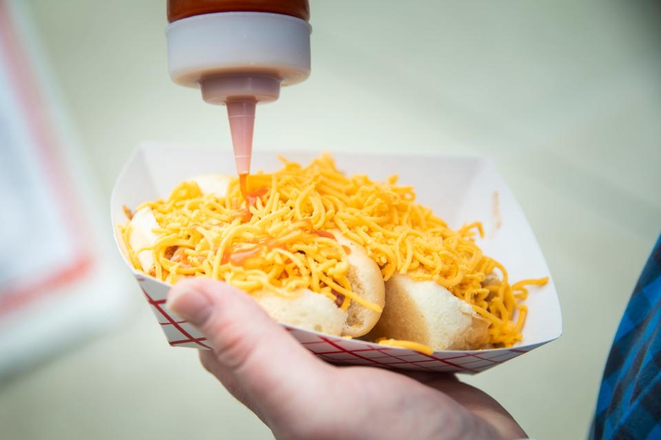 The Chili Hut serves cheese coneys at the Food Truck Takeover on Second Street between Rosa Parks and Race Streets in downtown Cincinnati Monday, April 29, 2019.