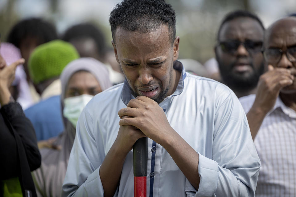 A man weeps before placing dirt into the burial site during the funeral of the five people killed in a car crash on Lake Street, at the Garden of Eden Islamic Cemetery in Burnsville, Minn., on Monday, June 19, 2023. (Elizabeth Flores/Star Tribune via AP)