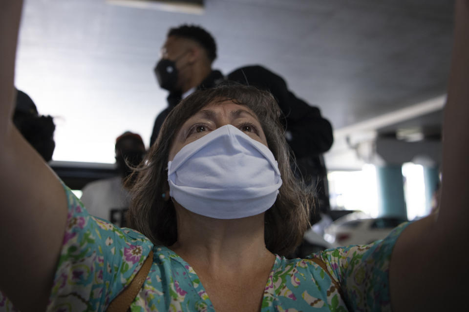 A woman takes a selfie with NBA Champion Giannis Antetokounmpo, background, of the Milwaukee Bucks, who was named NBA Finals Most Valuable Player, at the Eleftherios Venizelos International Airport, in Athens, Greece, Sunday, Aug. 1, 2021. The NBA champion and finals MVP plans to stay in Greece for a few days, before returning to the U.S., where his girlfriend expects their second child later this month. (AP Photo/Michael Varaklas)