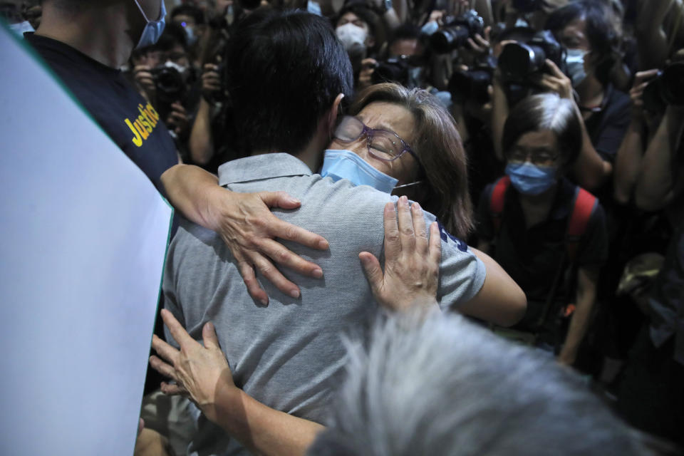 Pro-democracy legislator Ted Hui, hugs a supporter after being released on bail outside a court in Hong Kong, Thursday, Aug. 27, 2020. Hong Kong police arrested 16 people, including two opposition lawmakers, on Wednesday on charges related to anti-government protests last year. (AP Photo/Kin Cheung)