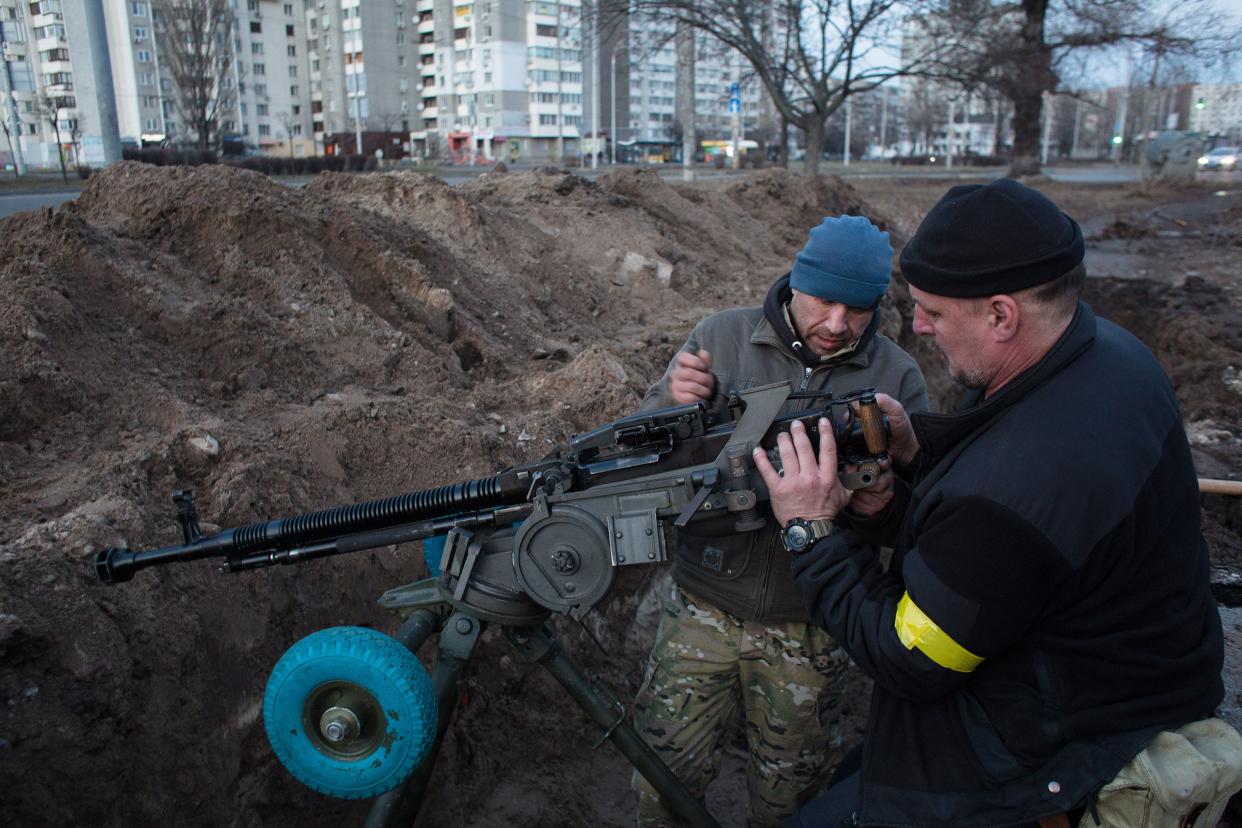 Members of the territorial defense battalion set up a machine gun and organize a military redoubt on Feb. 25, 2022, in Kyiv, Ukraine.