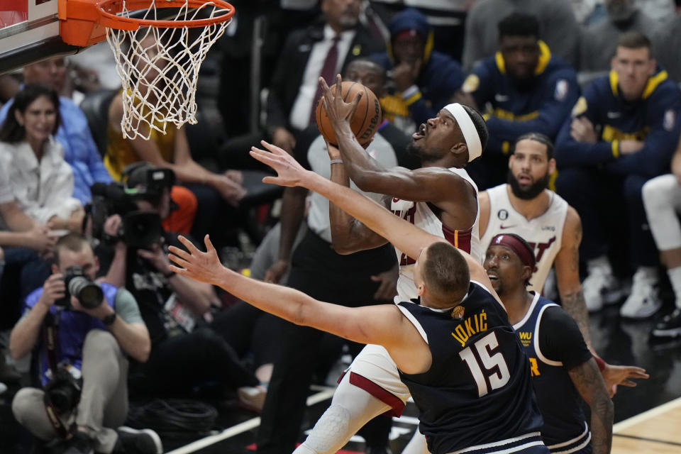 Miami Heat forward Jimmy Butler (22) drives to the basket as Denver Nuggets center Nikola Jokic (15) during the second half of Game 4 of the basketball NBA Finals, Friday, June 9, 2023, in Miami. (AP Photo/Lynne Sladky)