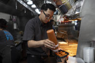 Lawrence Cheng, whose family owns seven Wendy's locations south of Los Angeles, works on an order in the kitchen at his Wendy's restaurant in Fountain Valley, Calif., June 20, 2024. When California’s minimum wage increase went into effect in April, fast food workers across the state went from making $16 to $20 overnight. It's already having an impact, according to local operators for major fast food chains, who say they are reducing worker hours and raising menu prices as the sudden increase in labor costs leaves them scrambling for solutions. (AP Photo/Jae C. Hong)