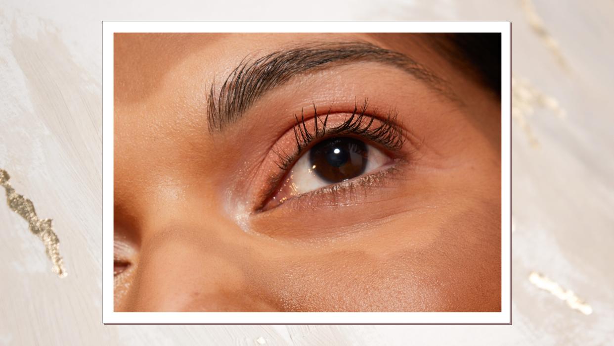  A close up of a woman's eye and eyelashes - which are long and fanned out/ in a gold foil and cream Christmassy template. 