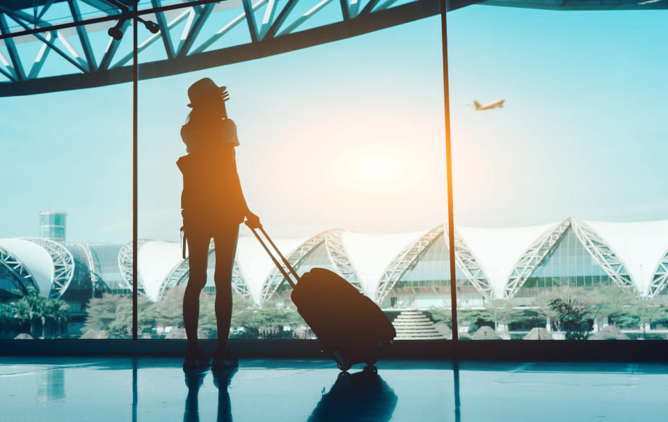 Woman with luggage standing in an airport. Source: Getty