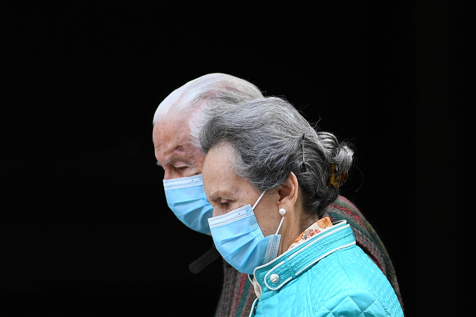 An elderly couple wearing face masks walks in Madrid on April 30, 2020 during a national lockdown to prevent the spread of the COVID-19 disease. - Spain counted another 268 people who have died from the coronavirus, the lowest daily number since March 20 as the country prepares to ease its tough lockdown measures. (Photo by Gabriel BOUYS / AFP) (Photo by GABRIEL BOUYS/AFP via Getty Images)