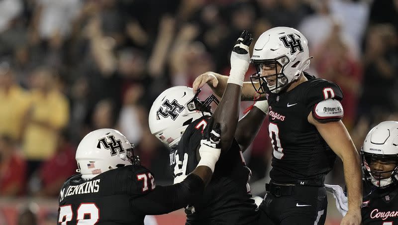 Houston wide receiver Joseph Manjack IV, right, celebrates a touchdown with Reuben Unije (74 )n and Tank Jenkins, left, during the third quarter of an NCAA college football game against West Virginia, Thursday, Oct. 12, 2023, in Houston. 