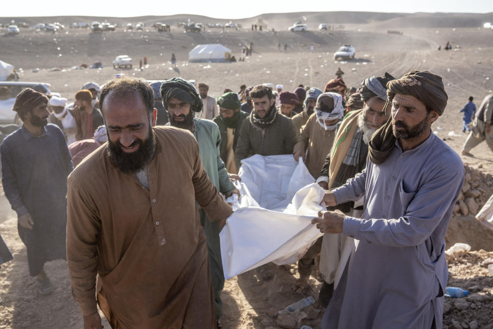 Afghan people carry the body of a relative killed in an earthquake at a burial site after an earthquake in Zenda Jan district in Herat province, western of Afghanistan, Monday, Oct. 9, 2023. Saturday's deadly earthquake killed and injured thousands when it leveled an untold number of homes in Herat province. (AP Photo/Ebrahim Noroozi)