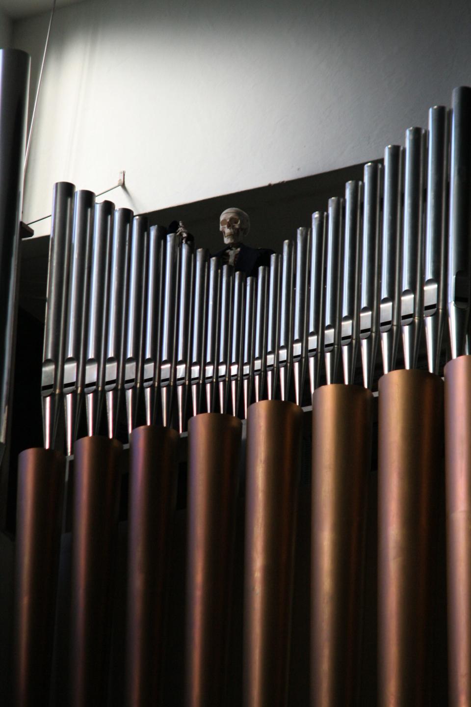 Skeleton atop pipe organ at Oslo City Hall in Norway