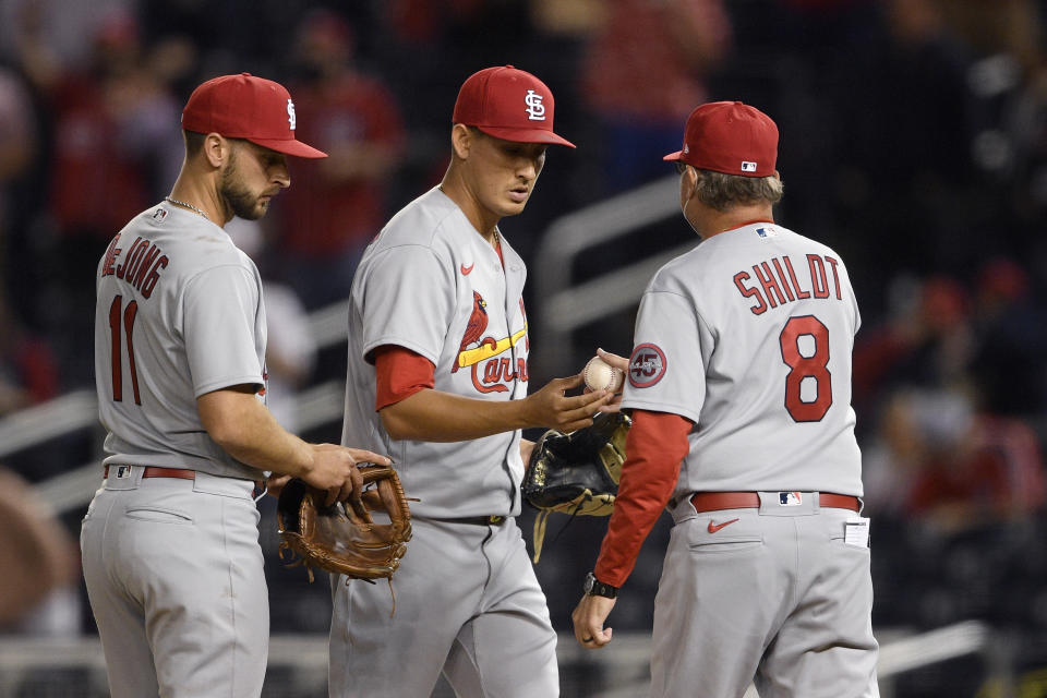 St. Louis Cardinals relief pitcher Giovanny Gallegos, center, is pulled from the baseball game by manager Mike Shildt (8) during the eighth inning against the Washington Nationals, Tuesday, April 20, 2021, in Washington. At left is Cardinals shortstop Paul DeJong. (AP Photo/Nick Wass)