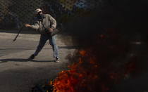 A demonstrator shows his slingshot as a message to police to not disperse a protest against the postponement of the presidential election in El Alto, Bolivia, Monday, Aug. 10, 2020. Citing the ongoing new coronavirus pandemic, Bolivia's highest electoral authority delayed presidential elections from Sept. 6 to Oct. 18, the third time the vote has been delayed. (AP Photo/Juan Karita)