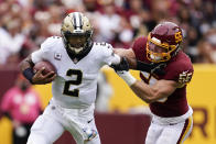 New Orleans Saints quarterback Jameis Winston, left, tries to outrun Washington Football Team linebacker Cole Holcomb in the first half of an NFL football game, Sunday, Oct. 10, 2021, in Landover, Md. (AP Photo/Alex Brandon)