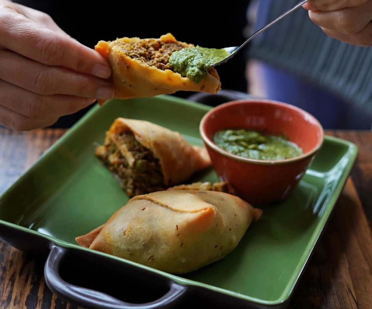 Indian-inspired lamb samosas get a bright lift from cilantro-mint chutney at Ela Curry & Cocktails restaurant in Palm Beach Gardens.