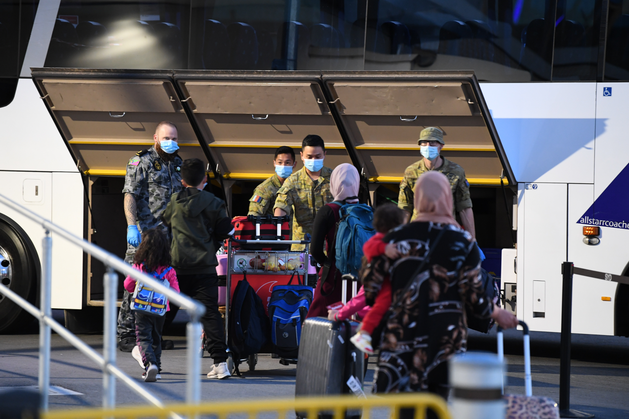 Passengers wearing face masks arrive to Sydney after a Qatar Airways flight on May 1, 2021. Australia banned flights from India earlier this week due to the escalating COVID-19 outbreak in India, but stranded Australians were still able to return on flights by transiting through Doha.