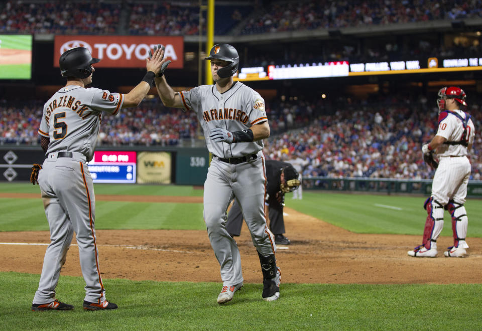 San Francisco Giants' Buster Posey, center, celebrates his two-run home run with Mike Yastrzemski, left, as Philadelphia Phillies catcher J.T. Realmuto stands near the plate during the sixth inning of a baseball game Wednesday, July 31, 2019, in Philadelphia. (AP Photo/Chris Szagola)