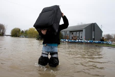 A resident removes belongings from his home in a flooded residential neighbourhood in Rigaud, Quebec, Canada May 7, 2017. REUTERS/Christinne Muschi