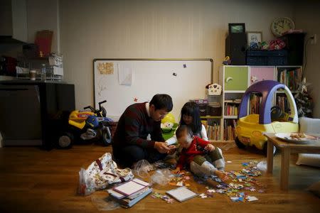Chung Sang-hoon talks to his daughter and son at their apartment in Seoul, South Korea, December 14, 2015. REUTERS/Kim Hong-Ji