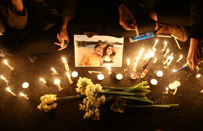 Personas y familias de las víctimas del accidente del avión Boeing 737-800, vuelo PS 752, encienden velas mientras se reúnen para mostrar sus condolencias en Teherán