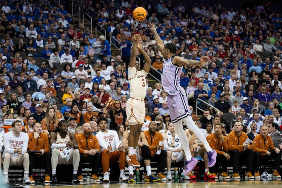 Texas guard Max Abmas shoots over Kansas State forward David N'Guessan during the second half. Abmas, playing in his first and last Big 12 Tournament, finished with 26 points, including a pair of late 3-pointers to keep the Longhorns close.
