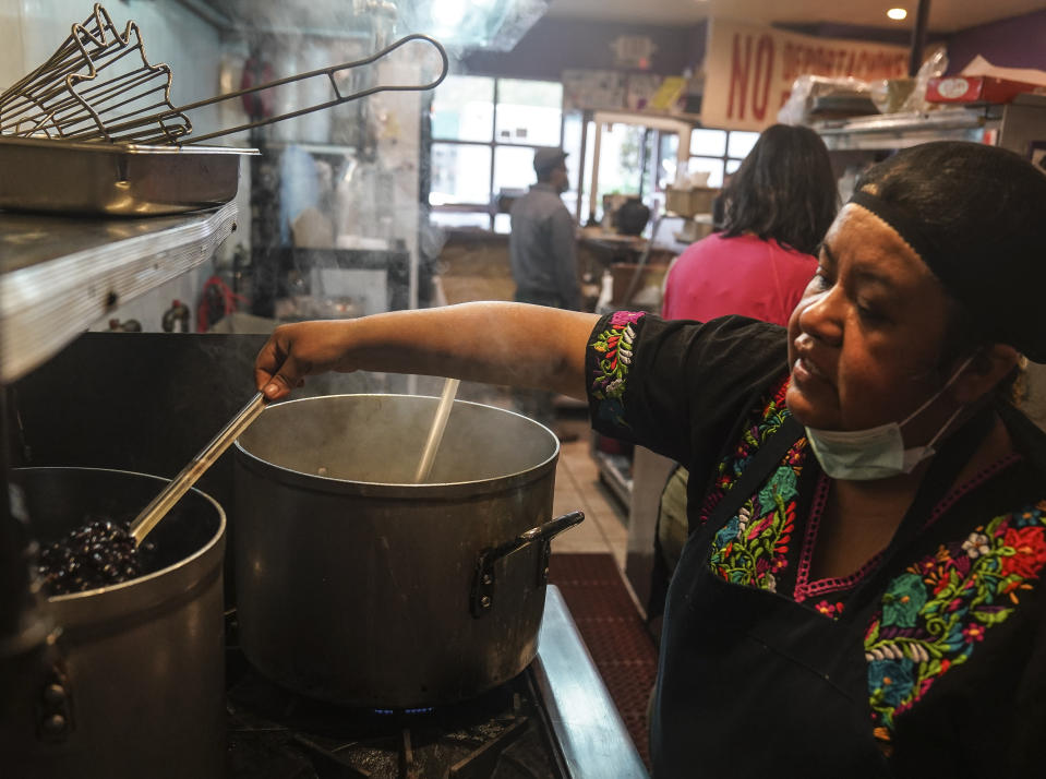 Natalia Méndez cooks in the kitchen of La Morada, an award winning Mexican restaurant she co-owns with her family in South Bronx, Wednesday Oct. 28, 2020, in New York. After recovering from COVID-19 symptoms, the family raised funds to reopen the restaurant, which they also turned into a soup kitchen serving 650 meals daily. (AP Photo/Bebeto Matthews)