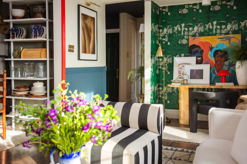 white and teal living room with one green and white wallpaper accent wall over workspace