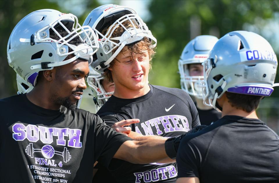 Bloomington South’s Ralph Rogers (left) and Tysen Smith talk with Duke Conrad during the first day of football practice at South on Monday, July 31, 2023.