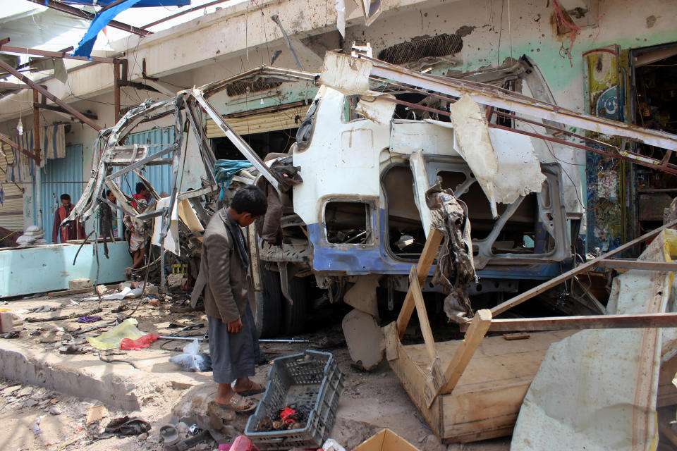 <p>A Yemeni child stands next to the destroyed bus at the site of a Saudi-led coalition air strike, that targeted the Dahyan market the previous day in the Huthi rebels’ stronghold province of Saada on Aug. 10, 2018. (Photo: Stringer/AFP/Getty Images) </p>