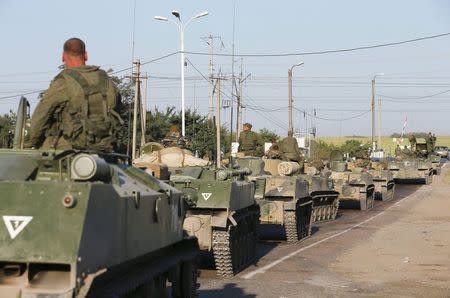 Russian military personnel sit atop armoured vehicles outside Kamensk-Shakhtinsky, Rostov Region, August 15, 2014. REUTERS/Maxim Shemetov