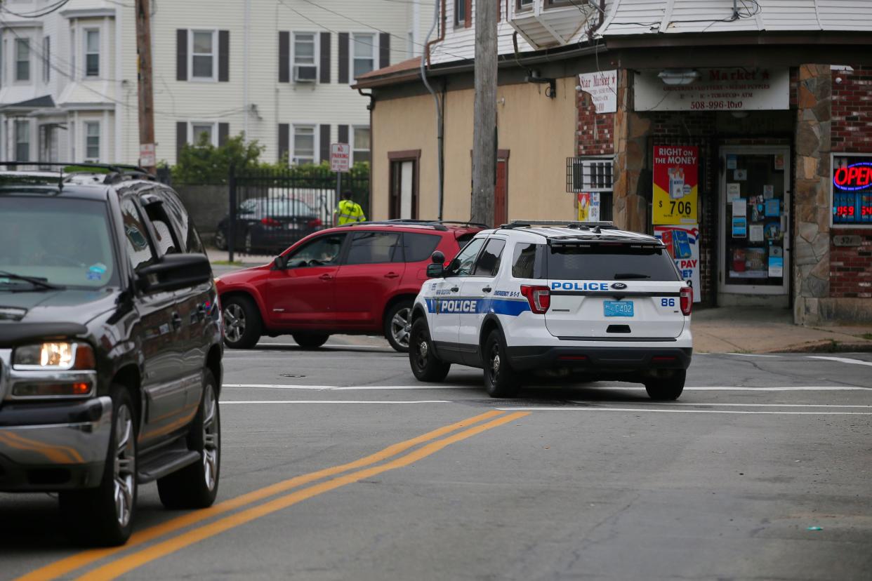 A New Bedford police cruiser drives past the intersection of Rivet Street and Orchard Street in New Bedford where Detective Lavar Gilbert was shot and wounded in July 2023 in this file photo in one of 67 shots-fired incidents in 2023. Two men have been arrested in connection with the shooting.